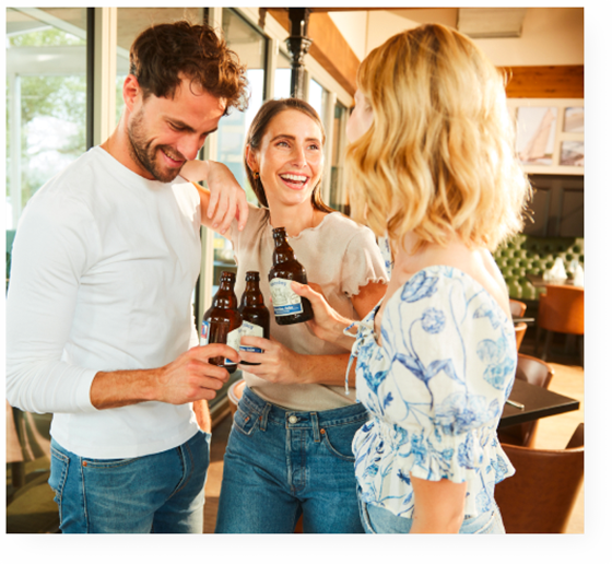 menschen stoßen mit bierflaschen an